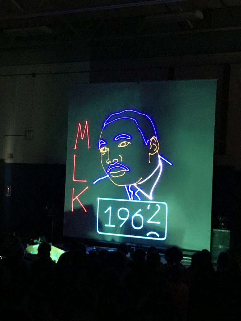 An image of Martin Luther King Jr. appears on the screen in laser light.