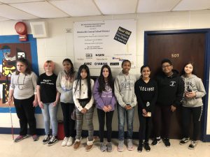 A group of middle school students standing smiling