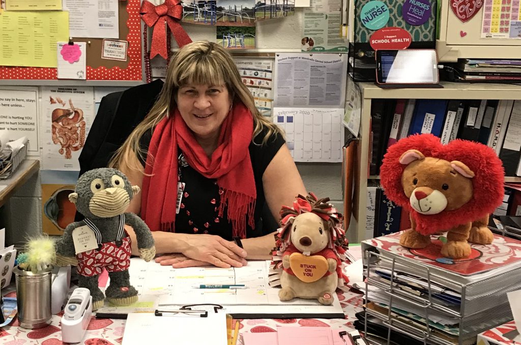 Sue Poli is sitting at her desk and smiling 