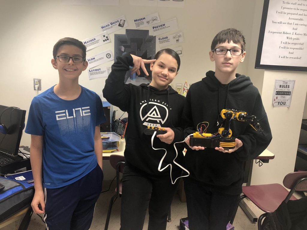 Seventh-grade Robert J. Kaiser Middle School students Skye Jenkins, Joseph Lasher are holding a robot 