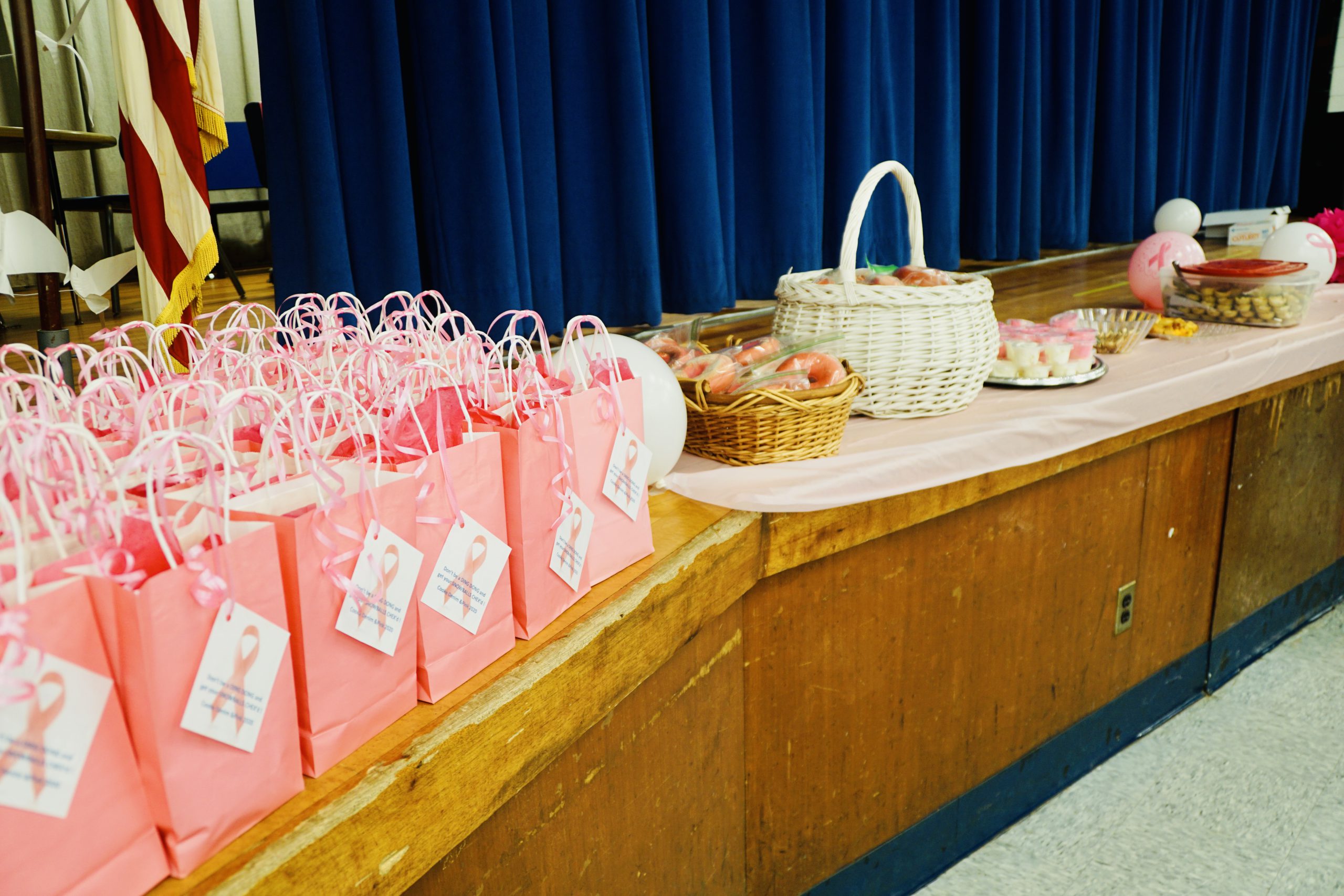 a row of pink goodie bags is lined up on a table