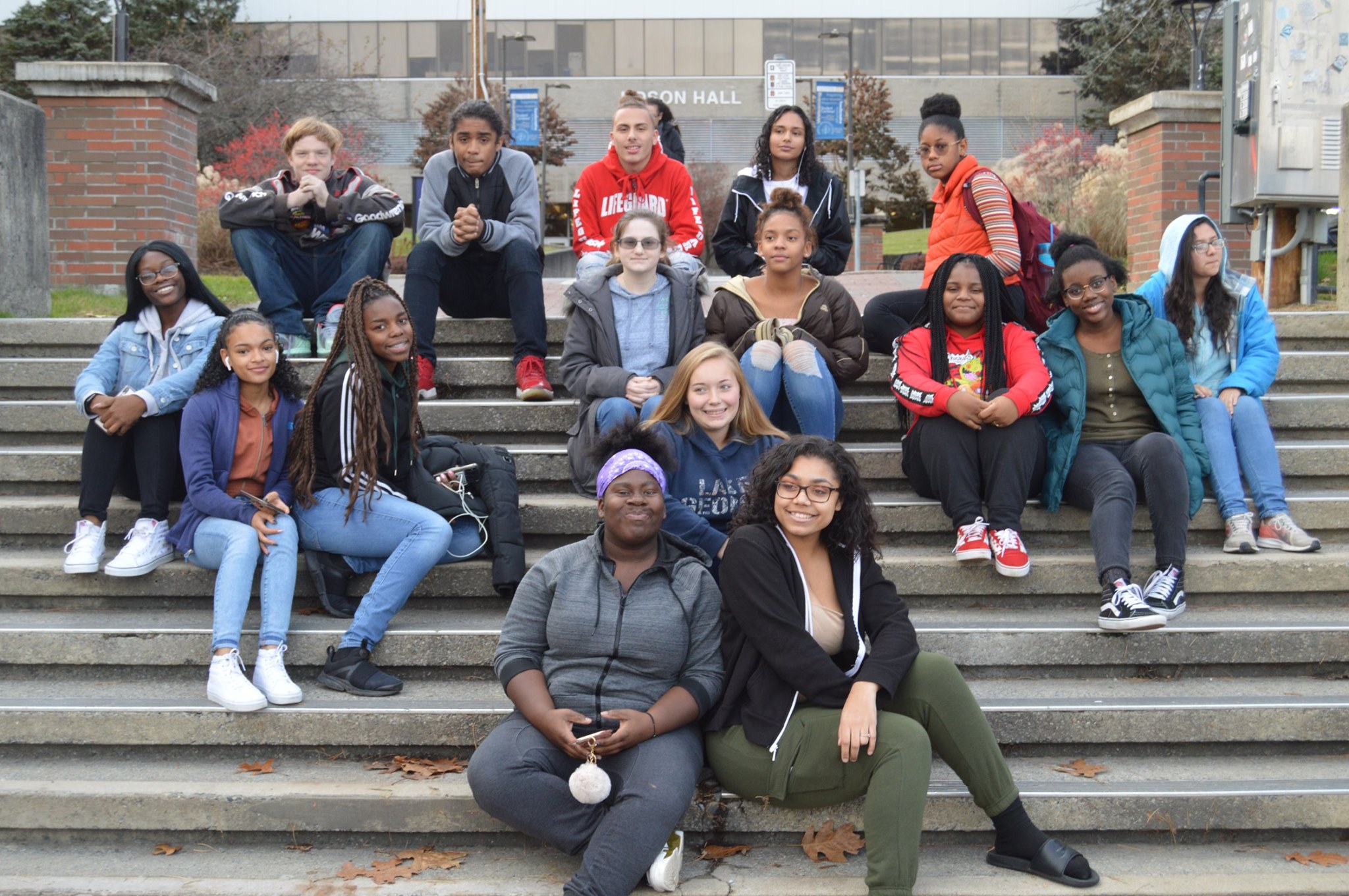 a group of teenagers are sitting on steps 