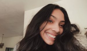 Up close photo of a young woman with a big smile and long dark hair