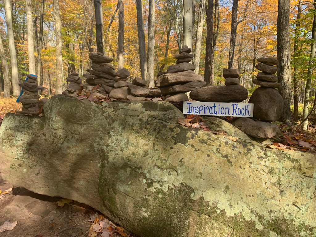 a group of rocks with a sign that says "inspiration rock" along the trail