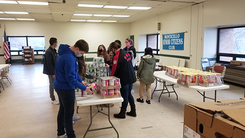 high school students begin filling white baskets with food