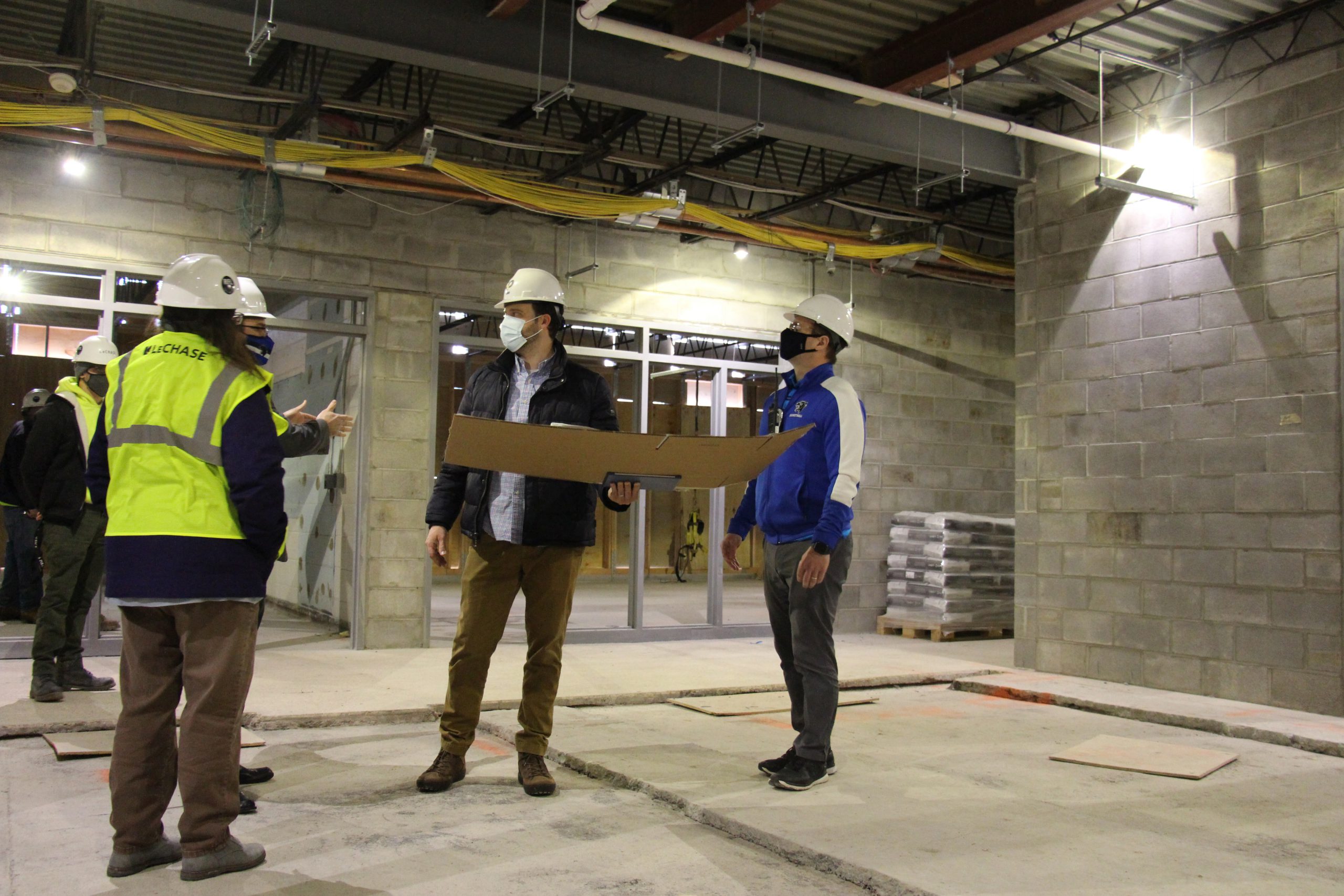 District administrators are in the building construction site and looking up 