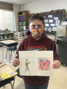 a student is holding up a valentines day card that he drew 