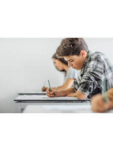 a student is sitting at a desk and writing