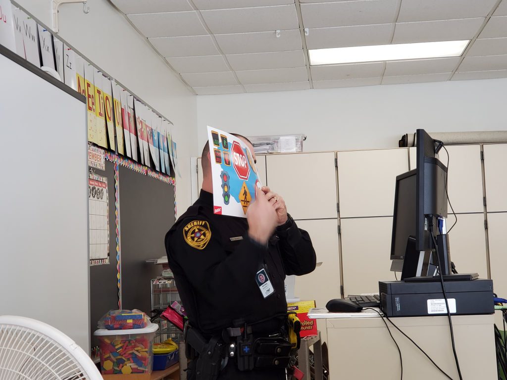 Deputy Barrett is holding up a book to a computer screen