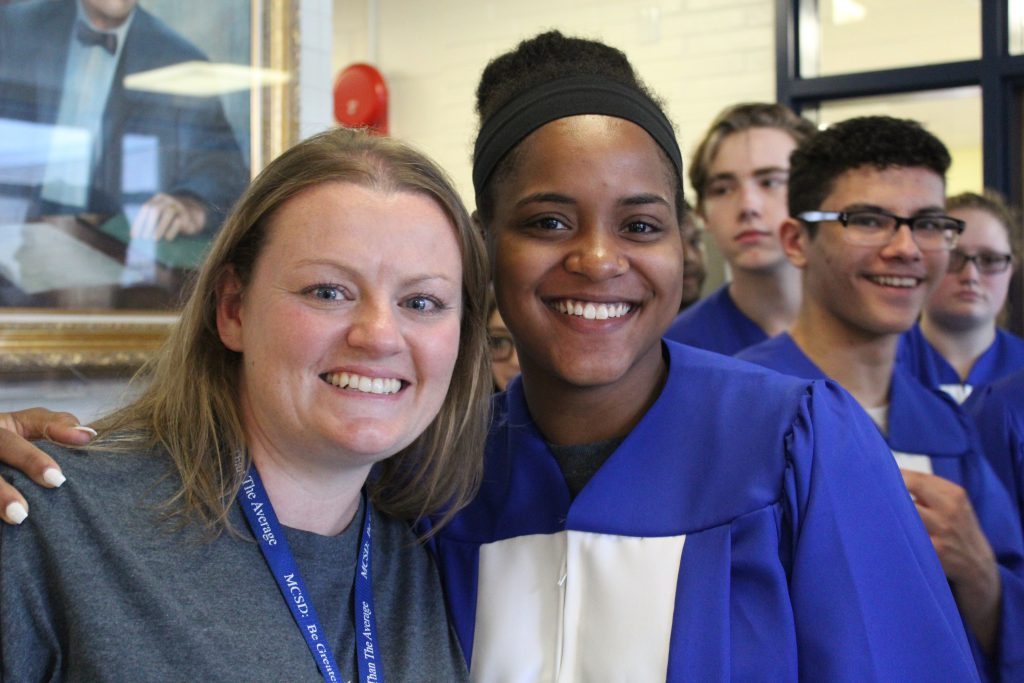 Melanie and student are in hallway smiling