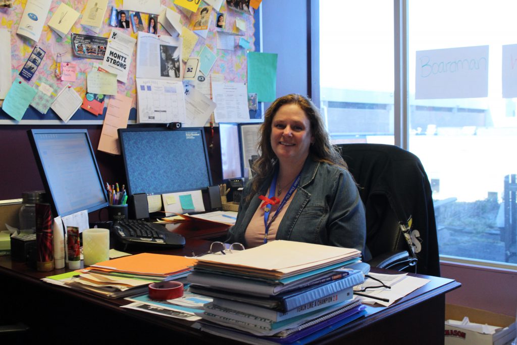 Robyn is sitting at a desk and smiling 