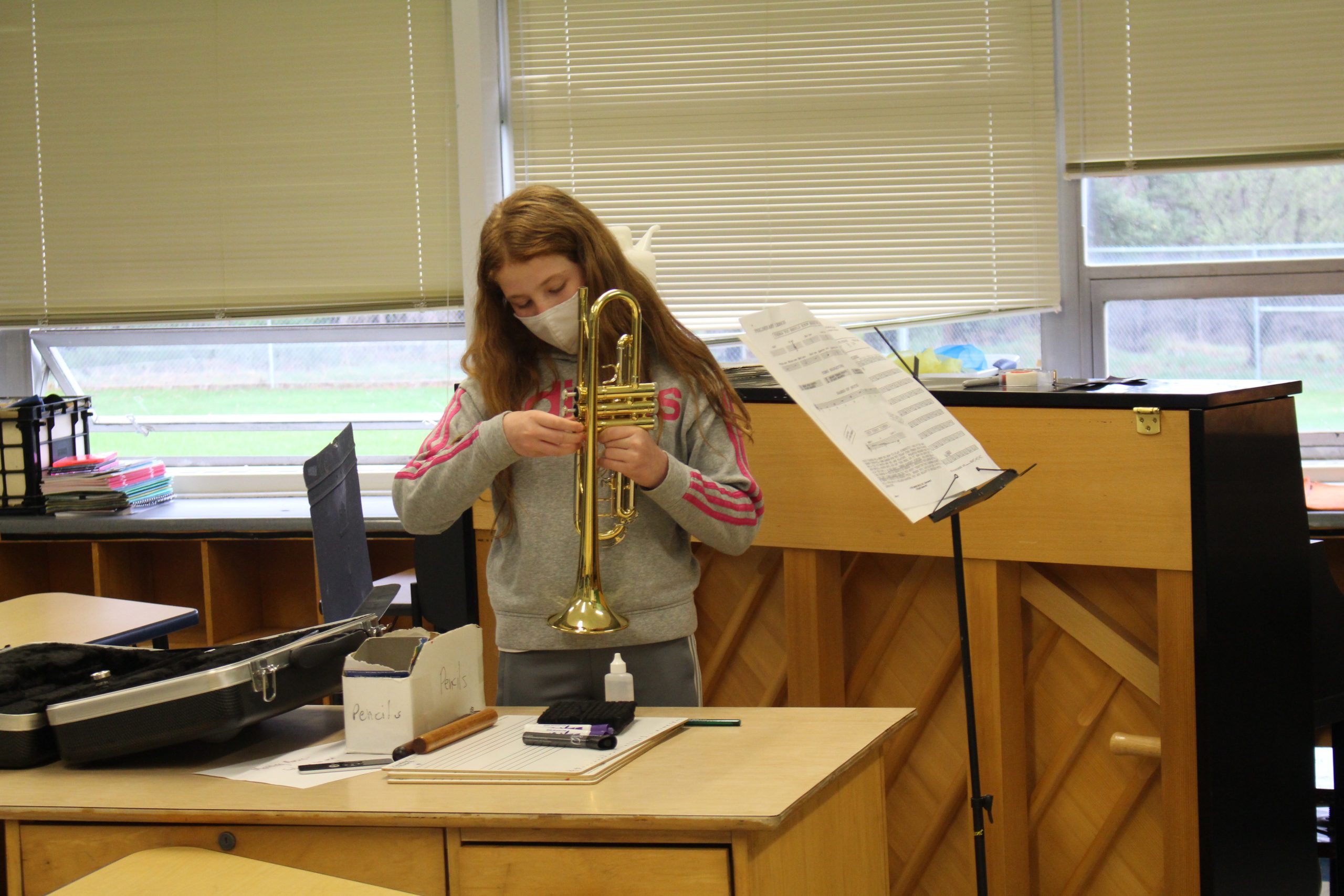 a girl is setting up her trombone