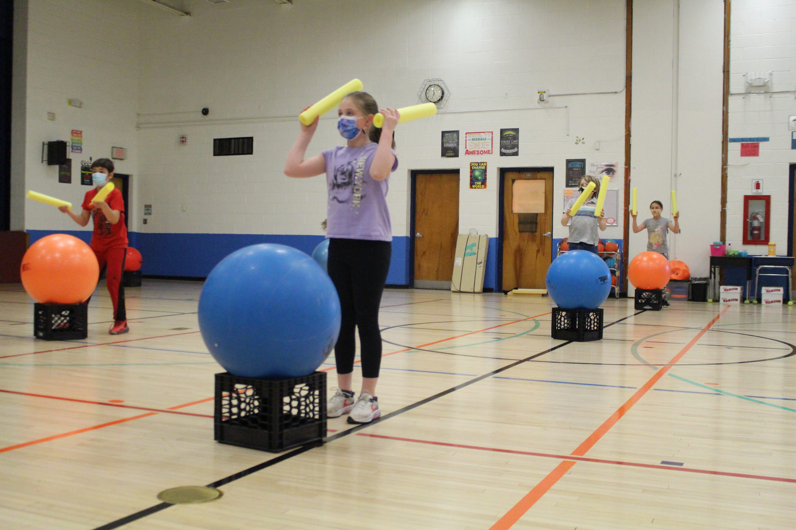 students are in a gym with cardio drums