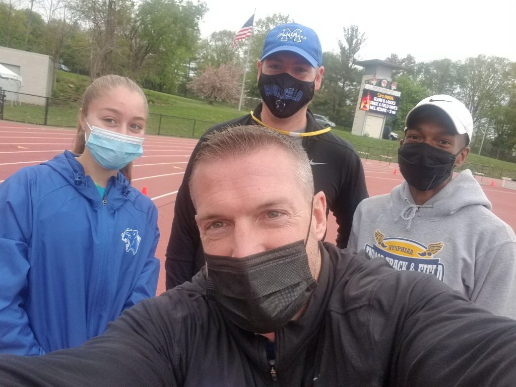 selfie of two track coaches with two athletes 