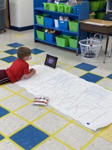 a student is drawing a sign that reads "thank you Petsmart"