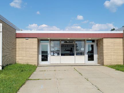 A tan building with large doors in the center