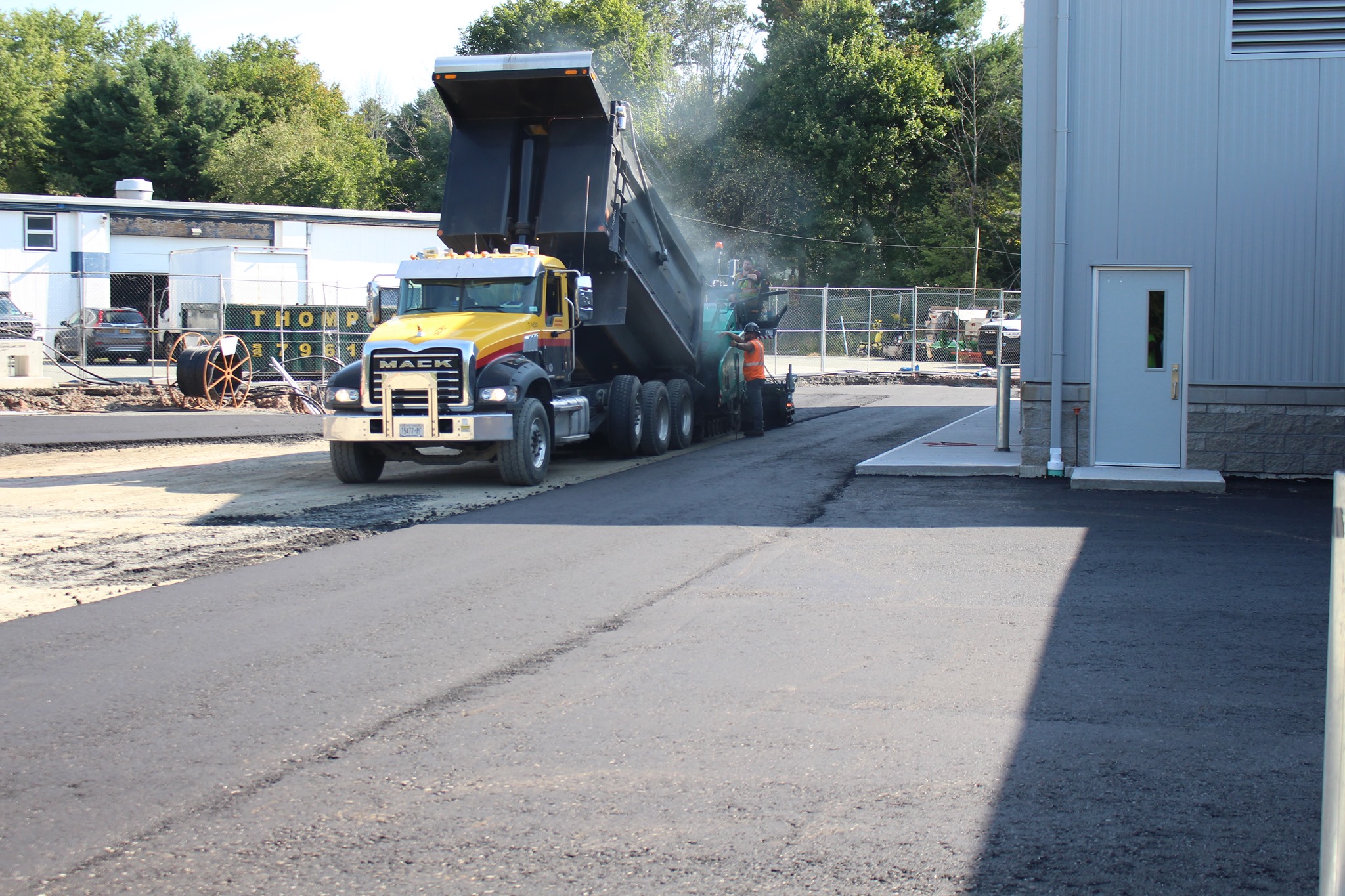 a truck is pouring blacktop outside the new transportation center 