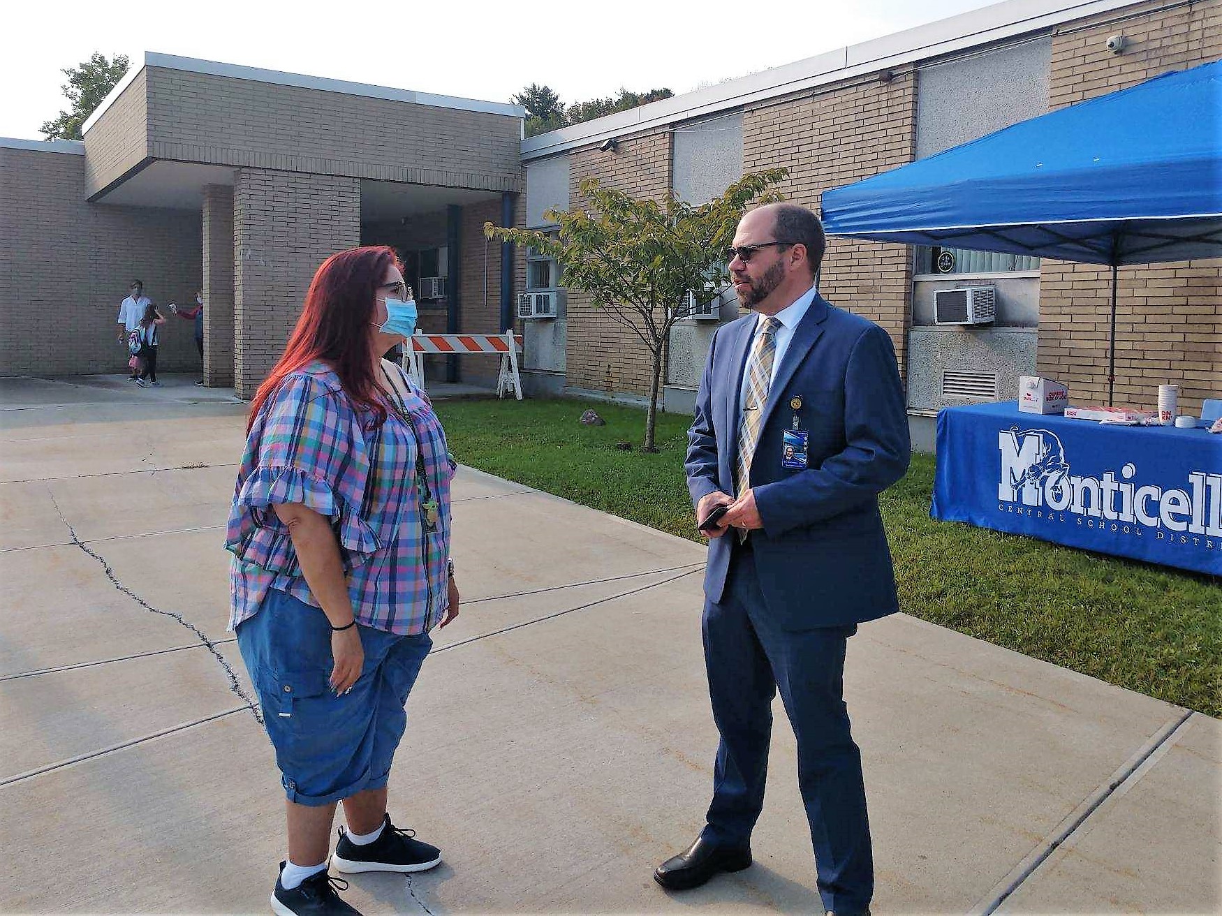 superintendent evans is outside of a school and speaking with a woman