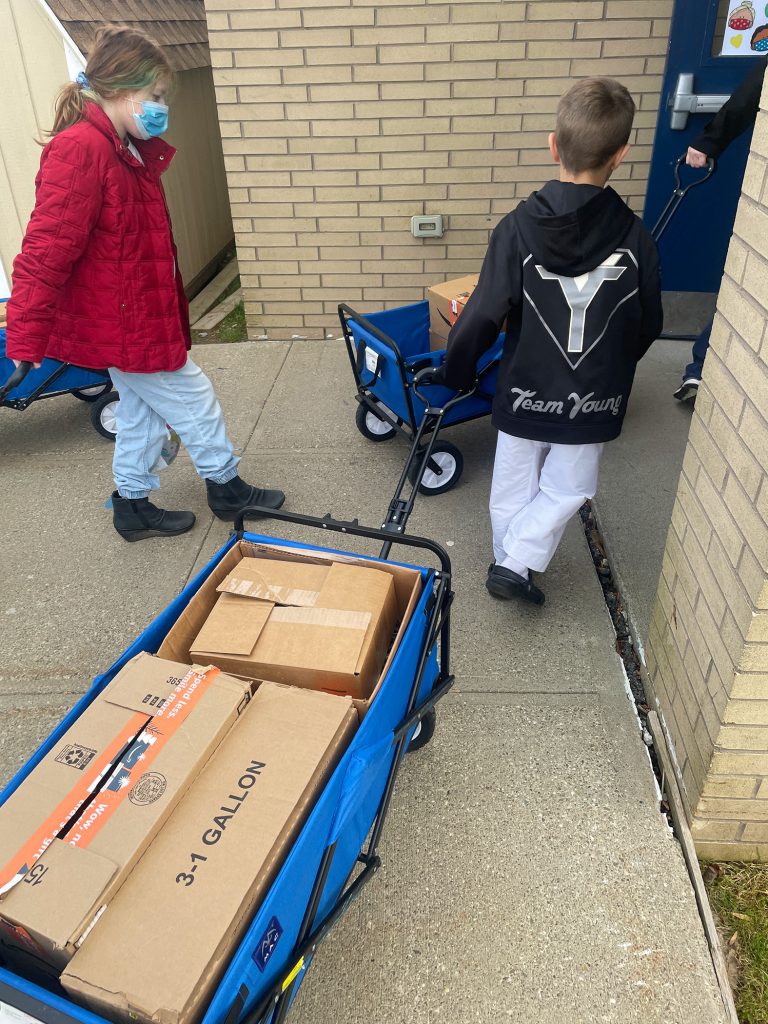 Two Team TKD members wheeling their donations into the building.