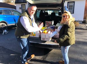 Local family loads Thanksgiving food donations into car.