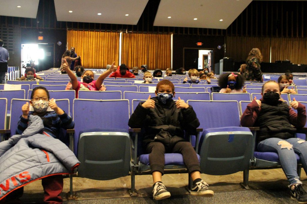 a group of third grade students are seated 