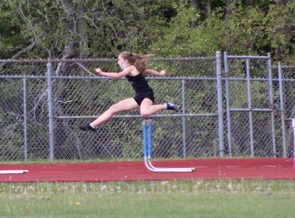 taina dejesus is jumping over a hurdle 