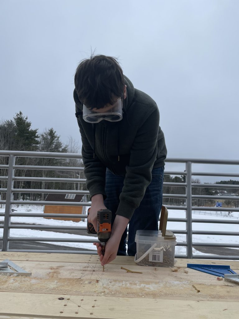 a student is drilling into a table