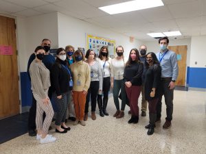 a large group of counselors is posing in a hallway 