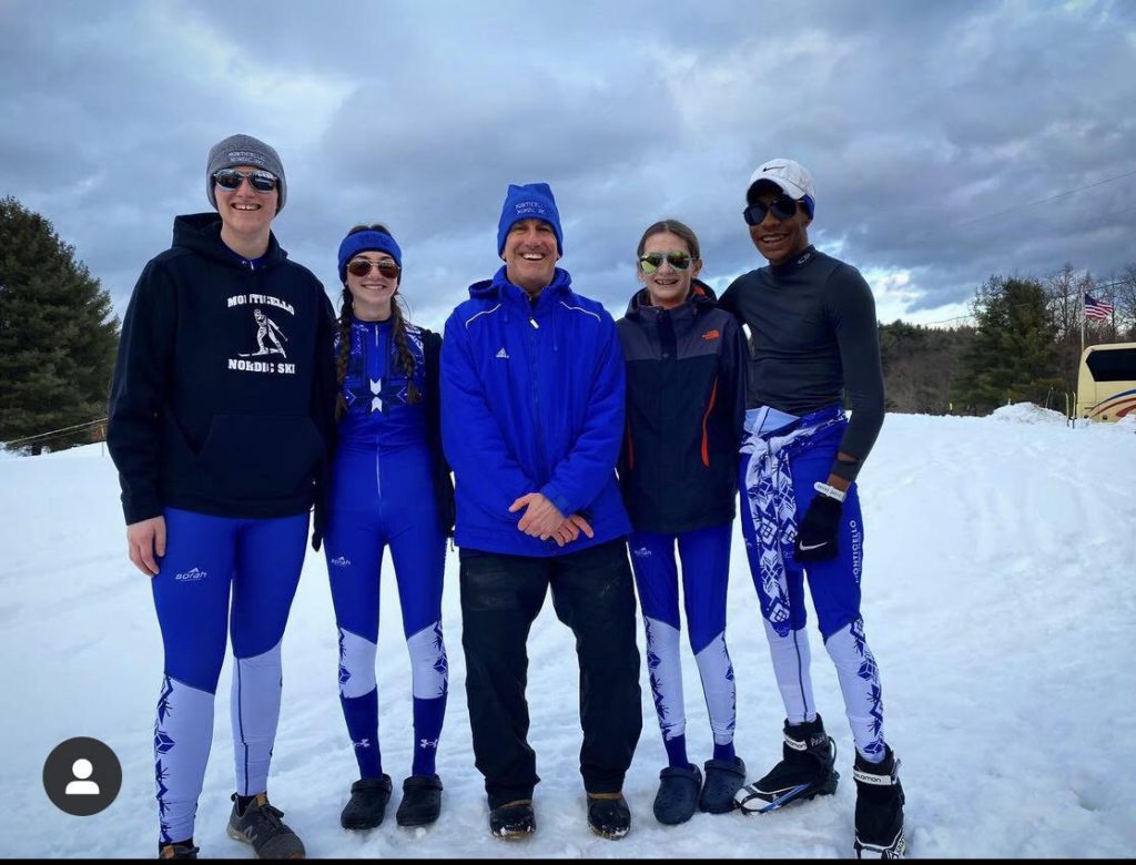 a group of skiiers is standing on a mountain