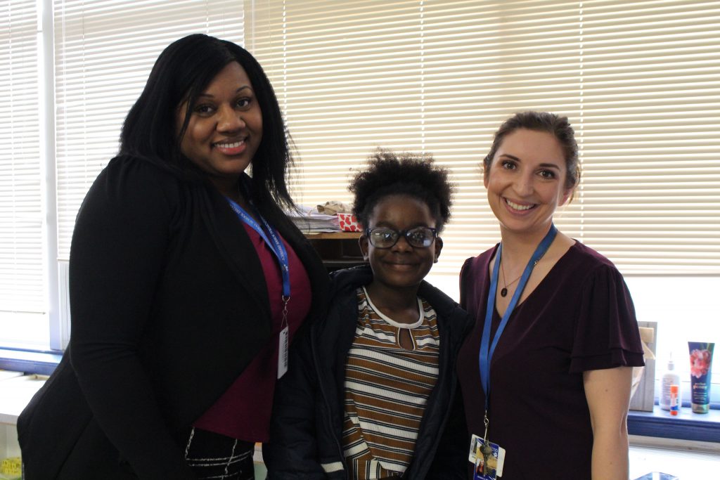 The Monticello Director of Student Equity, a teacher and a student are posing and smiling 