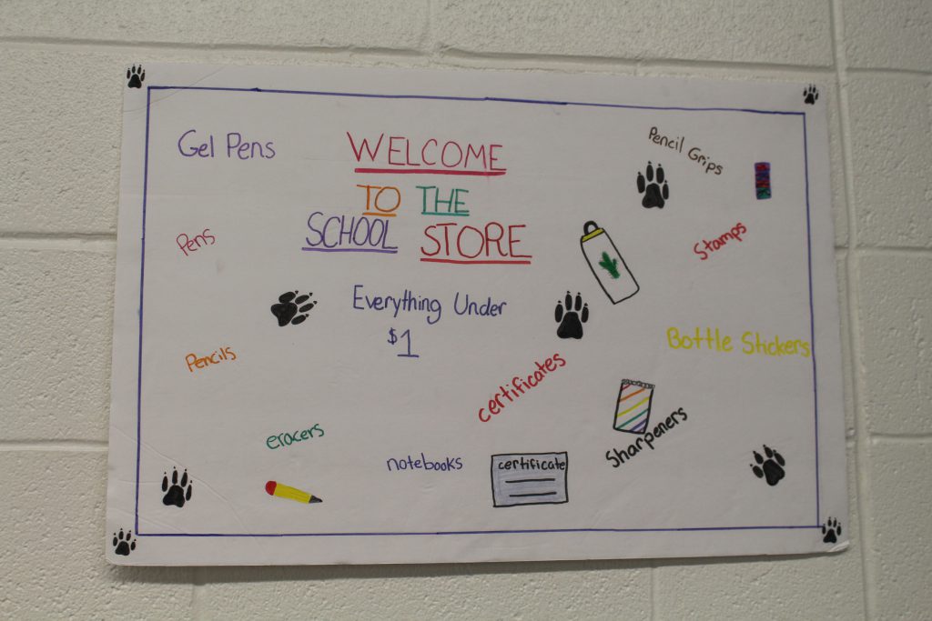 a hand-drawn sign advertising the school store 