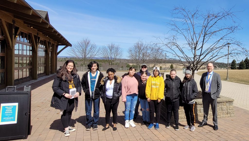 a group of students is posing outside of Bethel Woods 