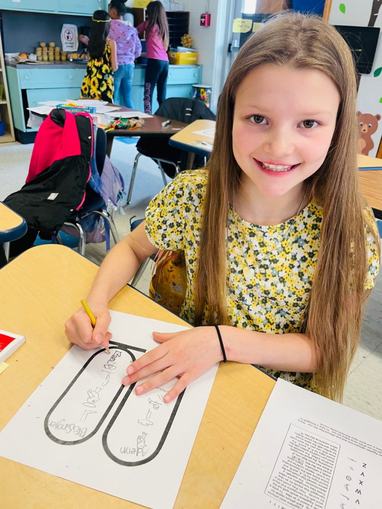 a young girl is working on a hieroglyphics worksheet