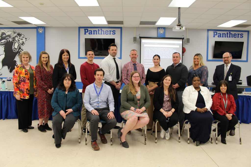 a group of educators are posing and smiling