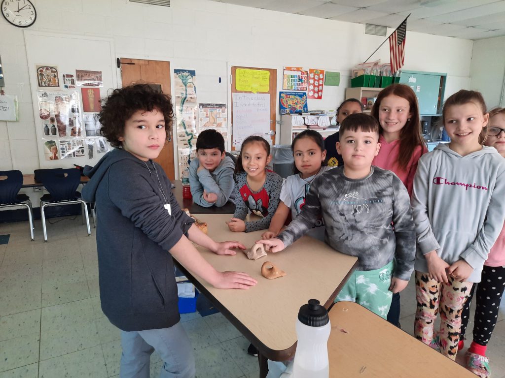 students are standing around a table