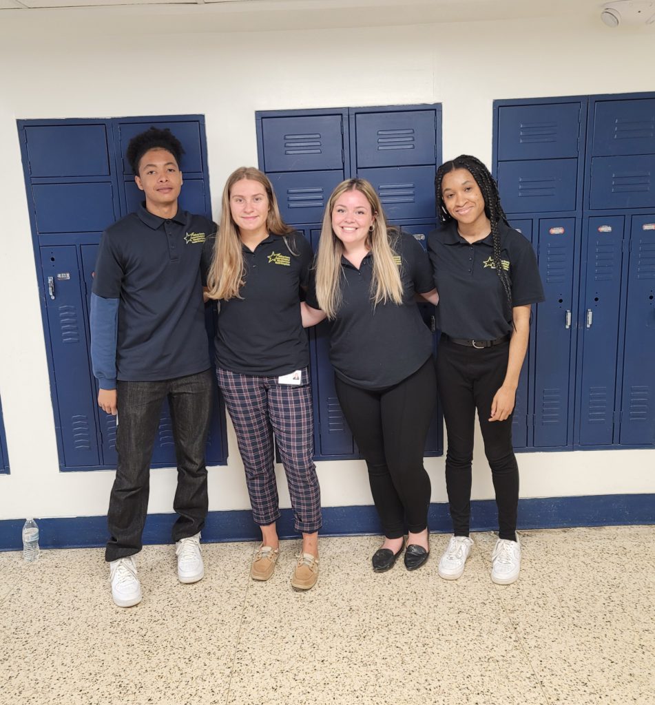 a group of students are smiling near lockers