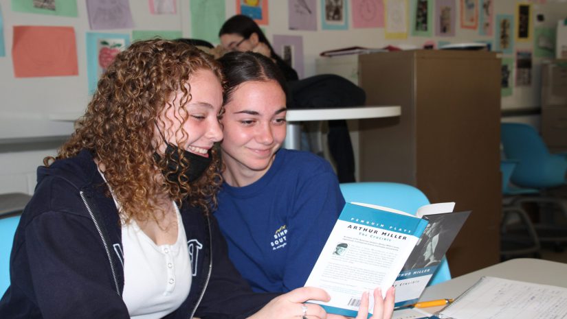 two female students are reading a book