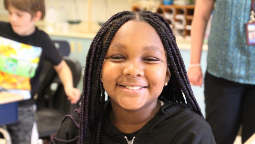 a female student with braids is smiling
