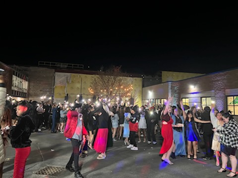 a group of teenagers in formal wear are dancing.