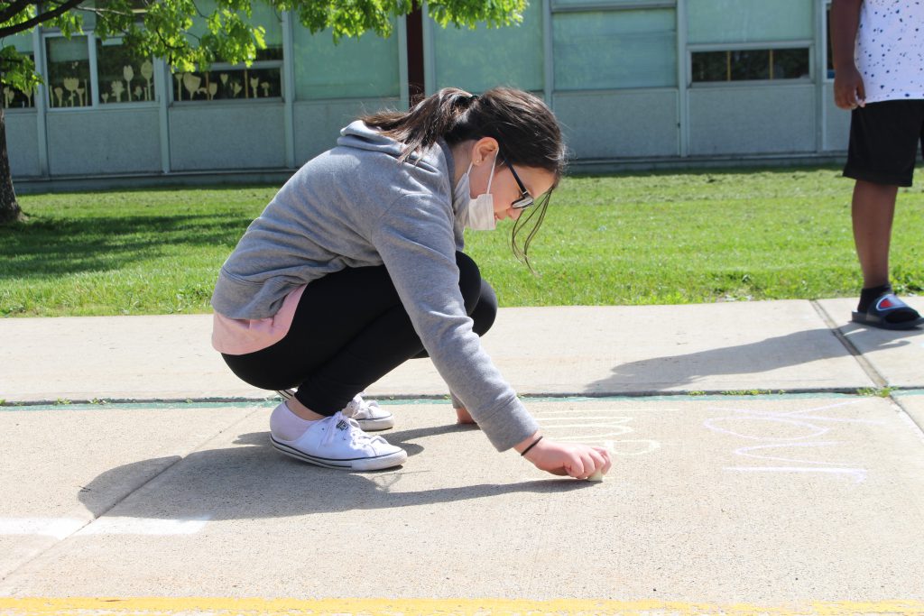 a student is drawing on the sidewalk
