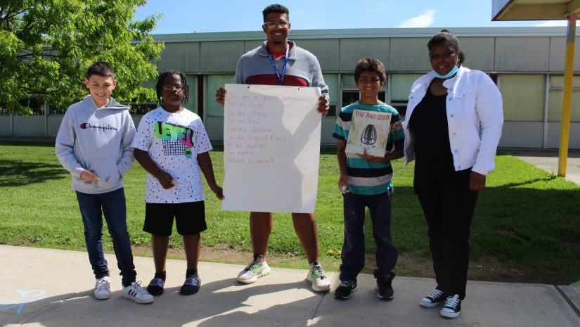 three students and two teachers are posing