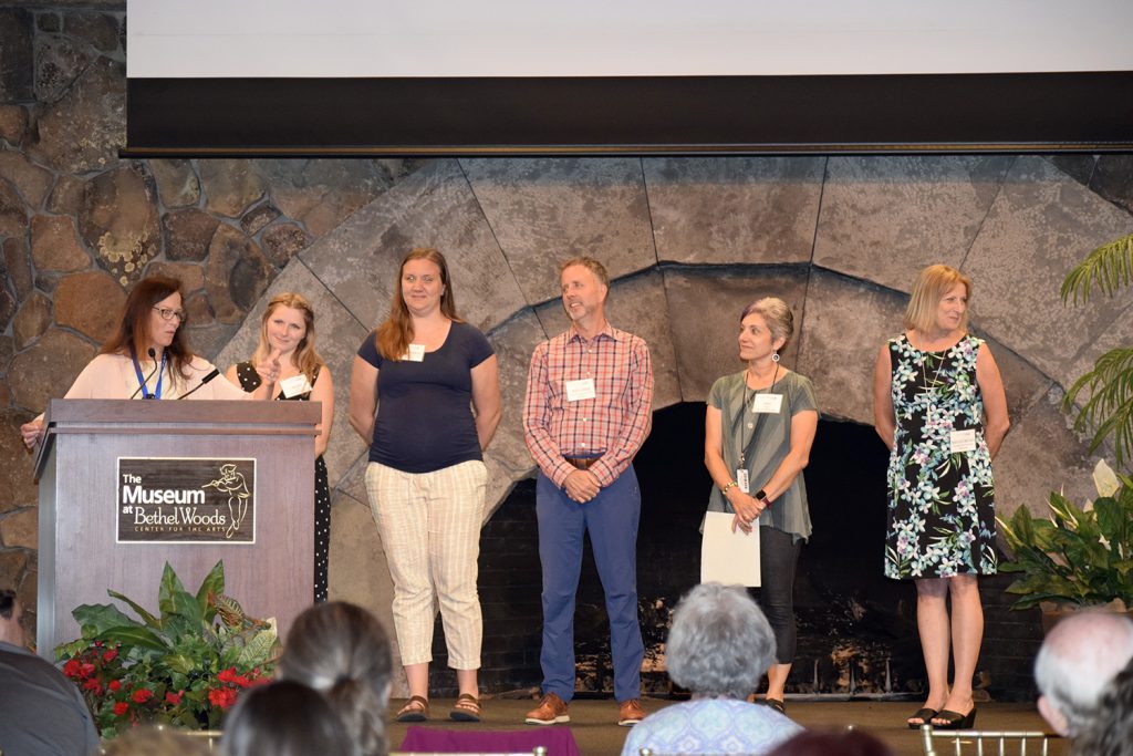 a group of educators is standing on a stage