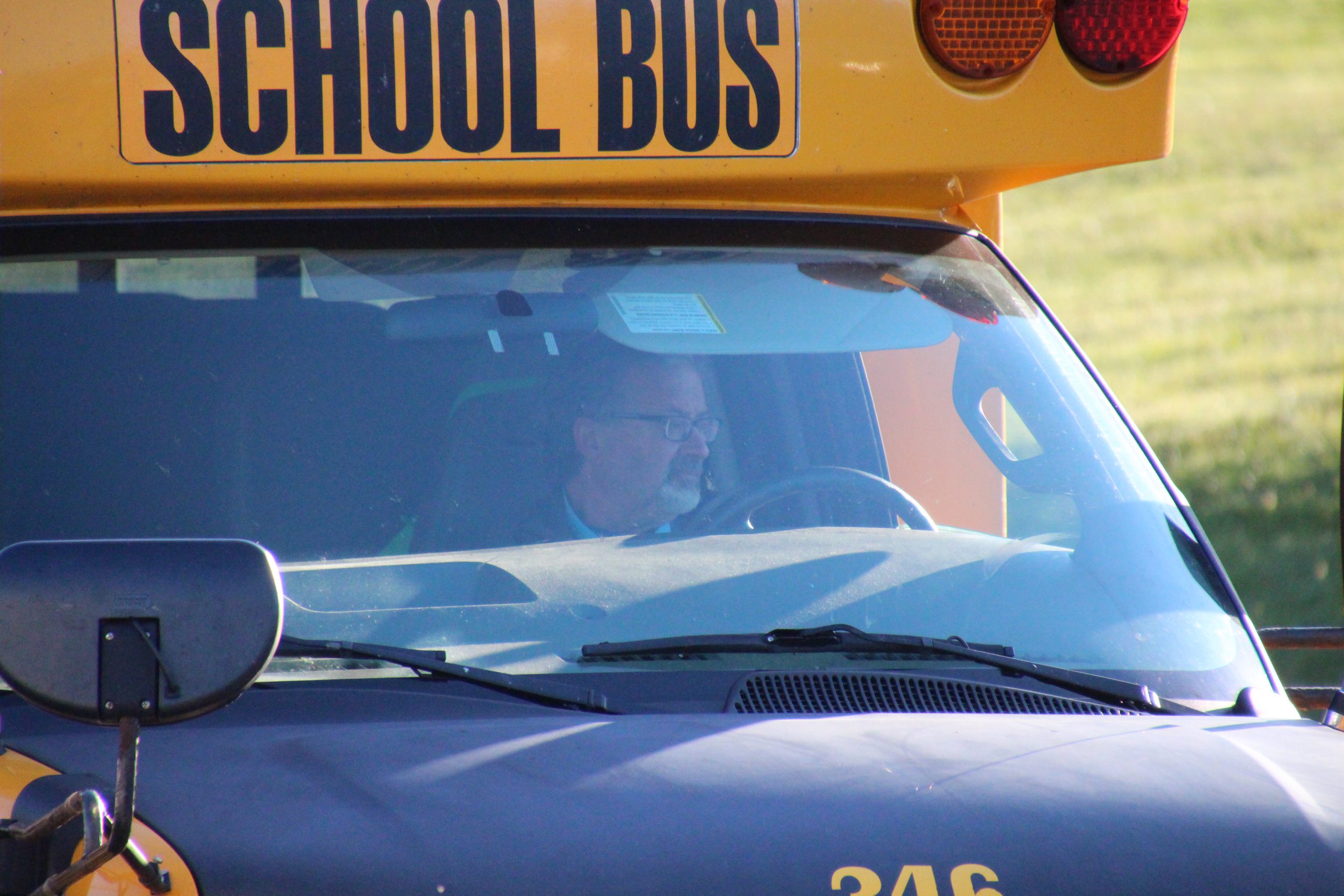 Up close shot of a bus driver driving a school bus.