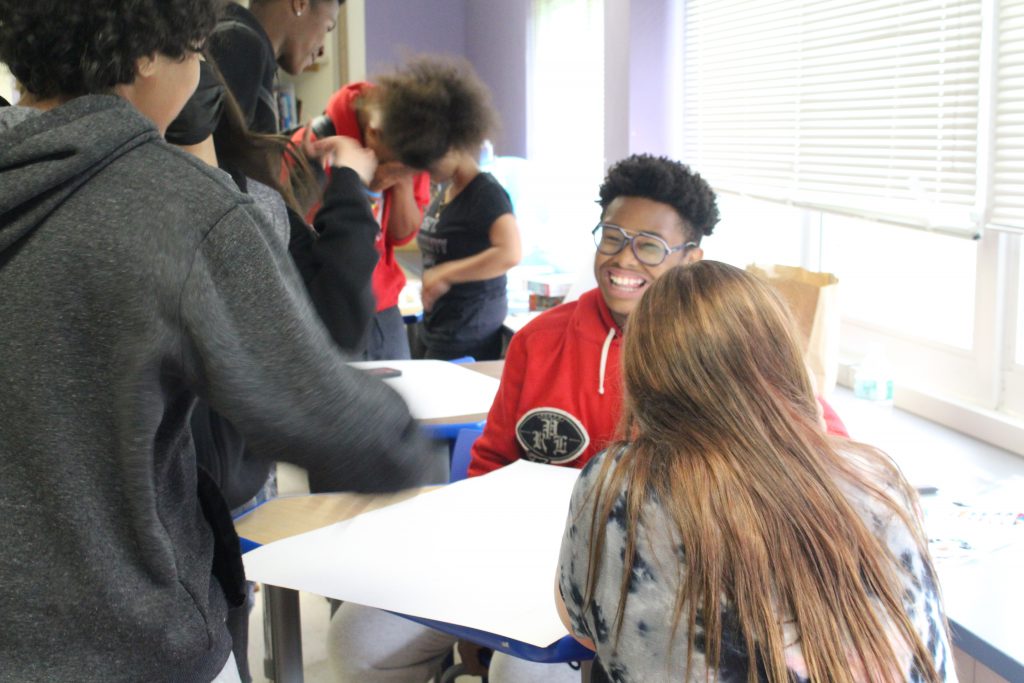 a student is seated and smiling 