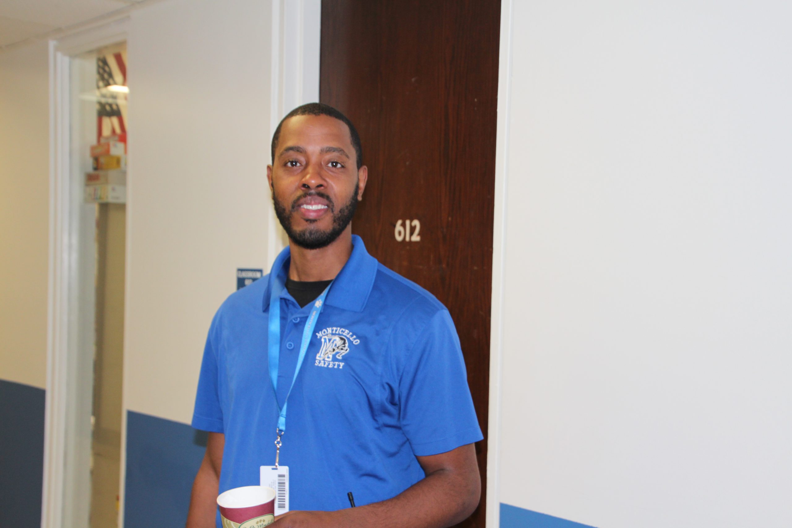 A Monticello security attendant is holding a coffee cup and smiling at the camera for a photo.