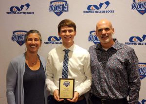 Owen Bassett is standing with his parents holding his OCIAA award. Everyone is smiling for a picture. 