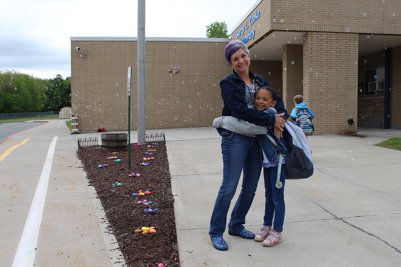 happy teacher and student outside elementary school