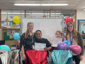 two speech pathologists are posing with two students 