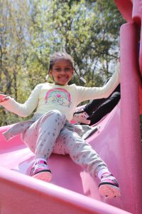 a young girl is sliding down a slide