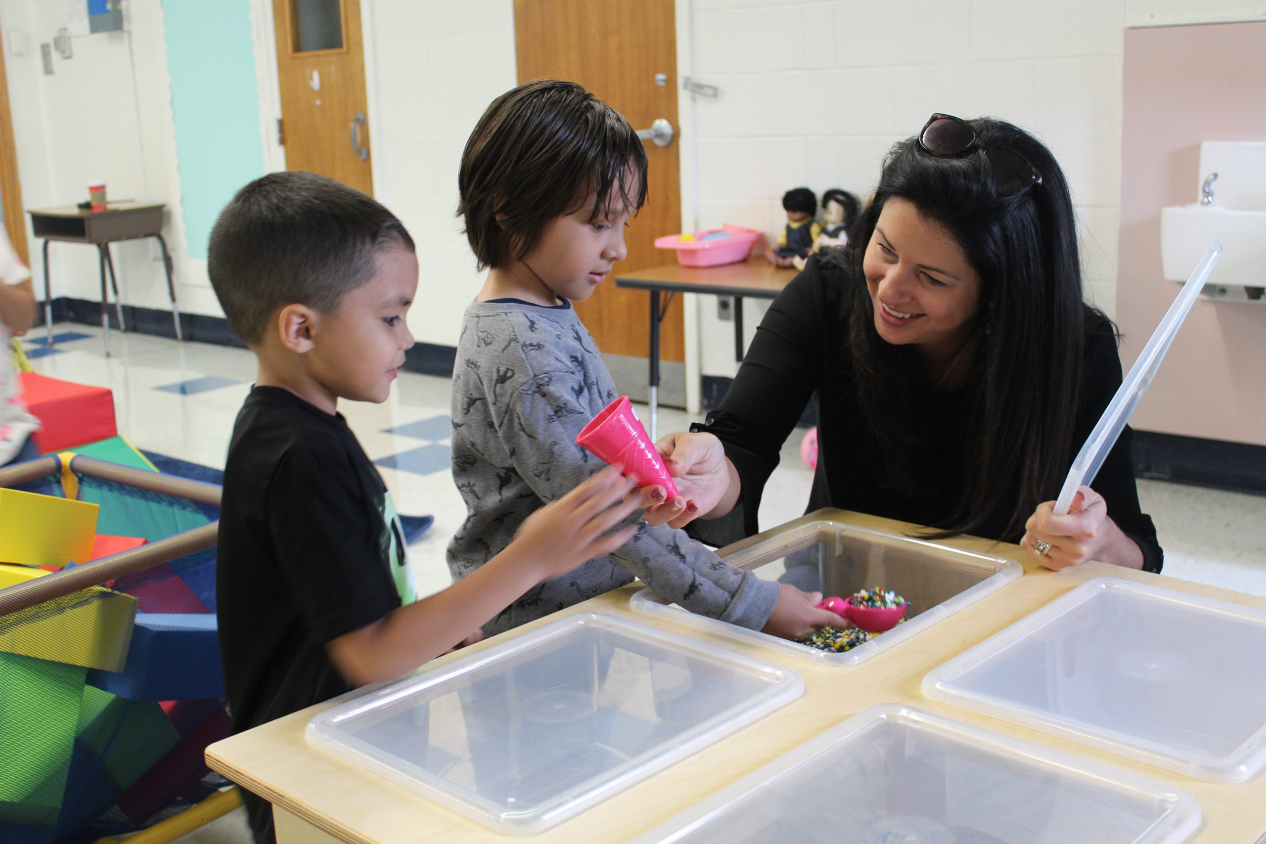 Teacher is assisting two students at a table